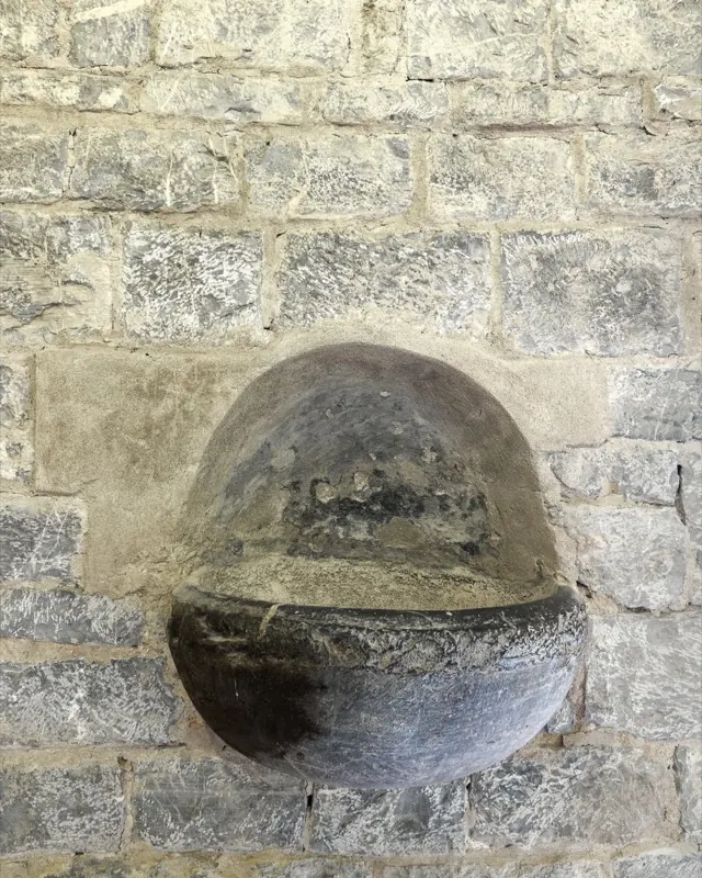 A stone basin set into the church wall