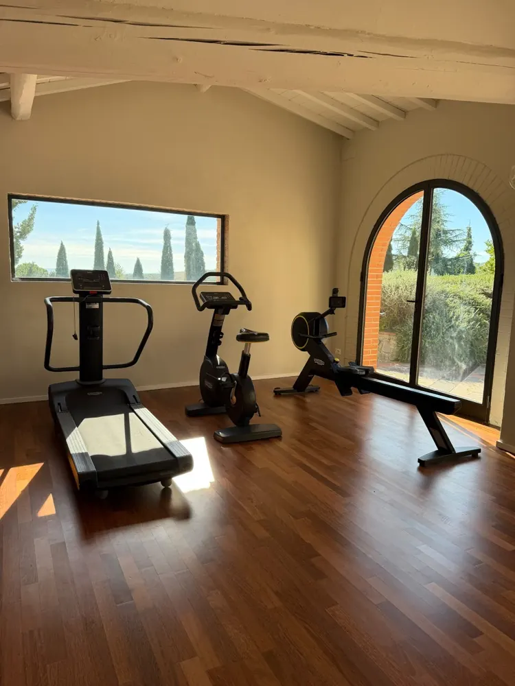 Der Fitnessraum, mit dem Bogenfenster zum Garten