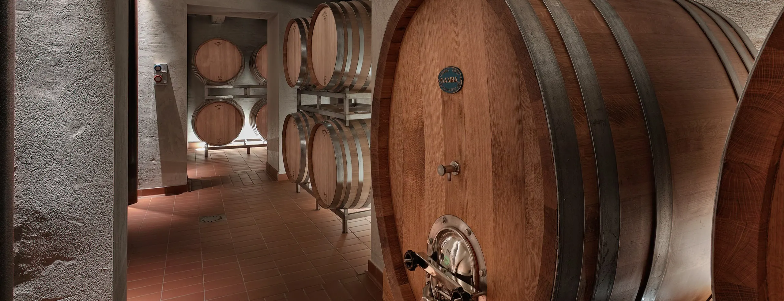 Large oak casks along the wall of the cellar under a beamed ceiling